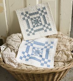 three quilts are sitting in a basket on the floor