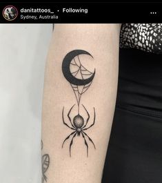 a spider with a crescent moon tattoo on it's arm