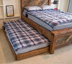 a bed that is made out of wood and has a plaid blanket on top of it