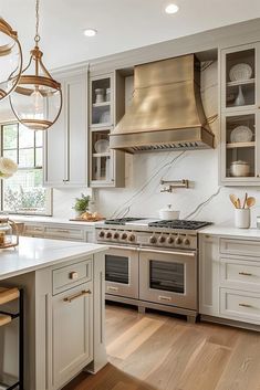 a kitchen with white cabinets and stainless steel stove top oven in the center, surrounded by wooden flooring