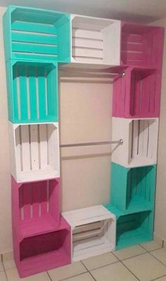 an empty closet is painted in pink, blue and white with shelves on each side