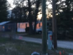 an rv parked on the side of a road next to a street sign and trees