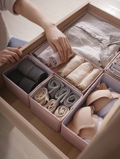 a drawer with several pairs of shoes in it and someone's hand reaching for them