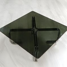 an upside down glass plate on a white table with black handles and two metal bars attached to it