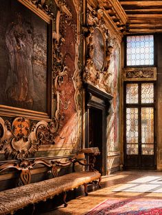 an ornately decorated room with benches and paintings on the wall