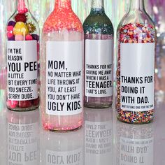 three bottles filled with different types of candy and confetti on top of a table