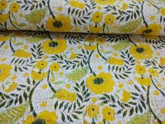 yellow and green floral print fabric with leaves on white background, close - up photo