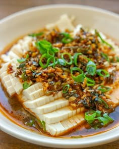 a white bowl filled with food on top of a wooden table