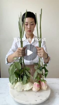 a woman is arranging flowers on a table