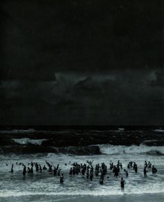 black and white photograph of people in the ocean