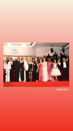 a group of people standing next to each other in front of a red carpeted floor