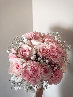 a bouquet of pink roses and baby's breath