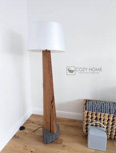 a wooden floor lamp next to a wicker basket