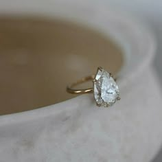 a diamond ring sitting on top of a white cloth