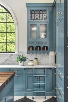 a kitchen with blue cabinets and marble counter tops