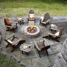 an outdoor fire pit with chairs around it