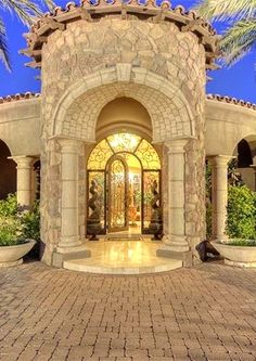 an entrance to a home with palm trees in the background