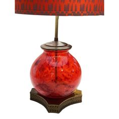 a red table lamp with an orange shade on it