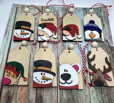 wooden tags with snowman, polar bear and reindeer hats on them hanging from strings