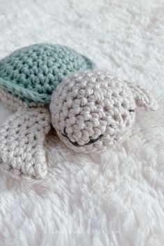 a crocheted turtle laying on top of a white blanket