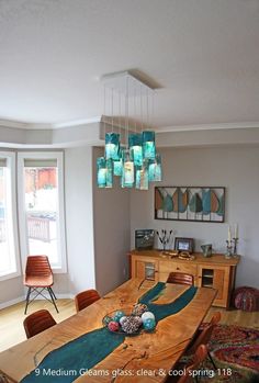 a dining room table with chairs and lights hanging from it's centerpieces