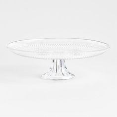 a clear glass cake plate sitting on top of a table