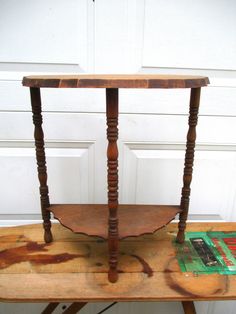 an old wooden table with two legs and a shelf on top that has been turned into a side table