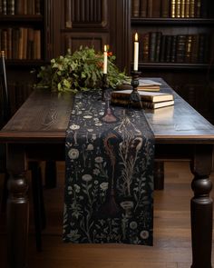 a table with a book and candle on it in front of some bookshelves