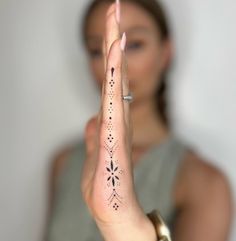 a woman is holding her hand up in the air with an intricate design on it