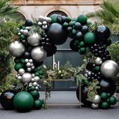 an arch made out of black and silver balloons