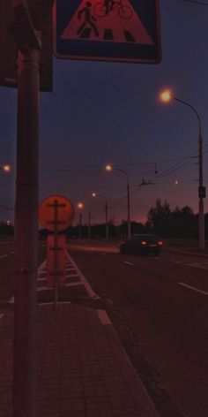 a red and blue sign on the side of a road next to a street light