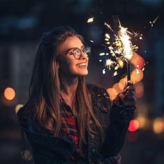 a woman holding a sparkler in her hand