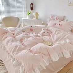 a bed with pink comforters and teddy bears on it