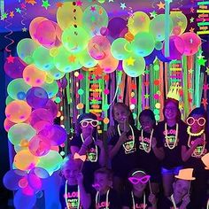 a group of young people standing next to each other in front of balloons and streamers