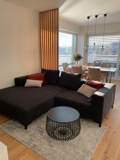 a living room filled with furniture next to a dining room table and window covered in blinds