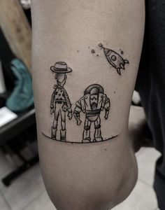 two people standing next to each other with an astronaut tattoo on their arm