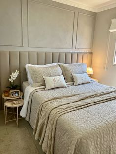 a bedroom with a bed, night stand and two lamps on either side of the bed