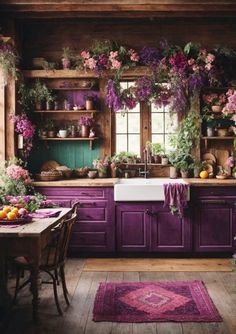 a kitchen with purple cabinets and lots of flowers on the counter top, along with an area rug