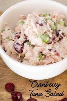 cranberry tuna salad in a white bowl on a wooden table with dried cranberries