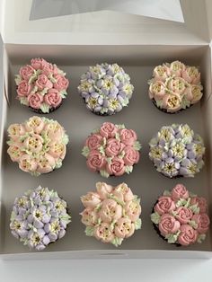 twelve cupcakes in a box decorated with flowers