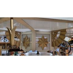 some gold stars are hanging from the ceiling in a room with bookshelves and other items