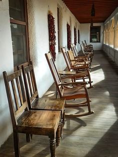 there are many rocking chairs lined up on the porch