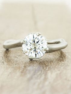 a diamond ring sitting on top of a wooden table