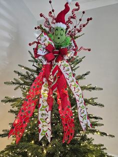 a christmas tree decorated with red, white and green ribbons