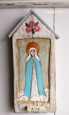 a small wooden house with a painting of the virgin mary on it's side