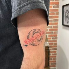 a man with a tattoo on his arm that reads the world is yours and has a red circle around it