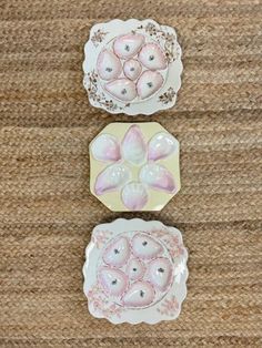 three plates with pink flowers on them sitting on top of a carpeted floor next to each other