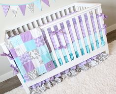 a white crib with purple and blue bedding