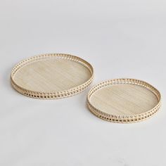 two round woven trays sitting on top of each other