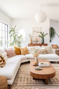 a living room filled with lots of furniture and plants on top of the couches